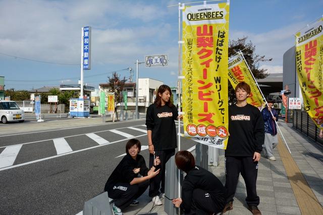 (写真)のぼり旗を広げてPRするQB選手