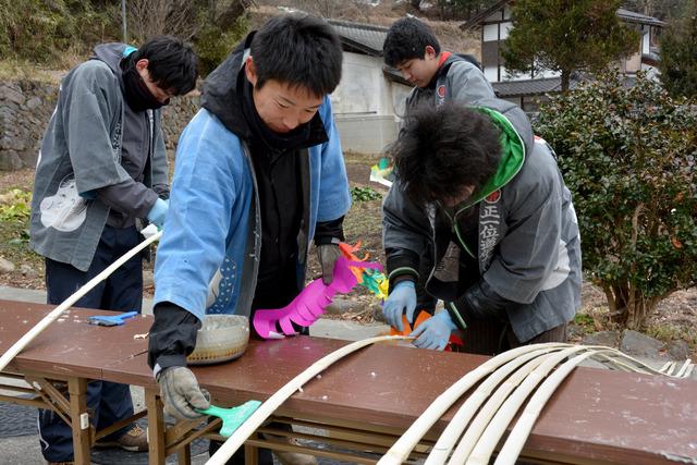 屋外で、大やなぎを作っている青年会のメンバーの写真