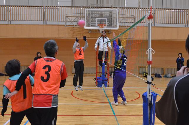 男性がジャンプしてボールをトスしている写真