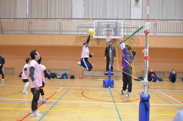 男性が大きくジャンプしてアタックしている写真