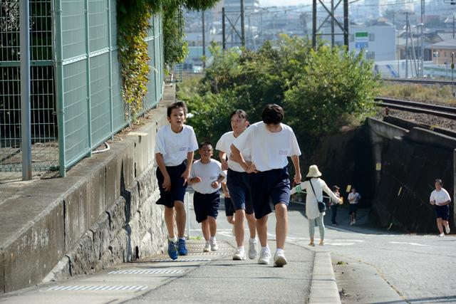 急な坂を走る生徒達の写真