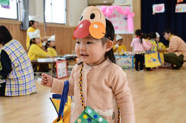 アンパンマンの手作りのお面を着けている小さい女の子の写真