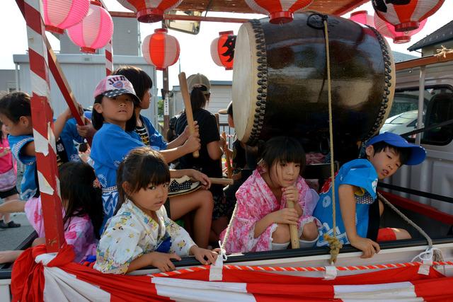 (写真)車に乗せられた太鼓をたたく子ども