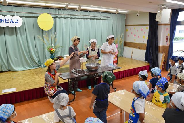 長寿会の丹沢さん、広兼さんから団子の作り方を教わる園児たちの写真