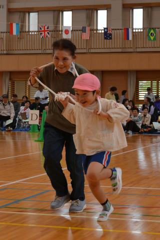 園児と高齢者がペアになって交流種目に参加している写真