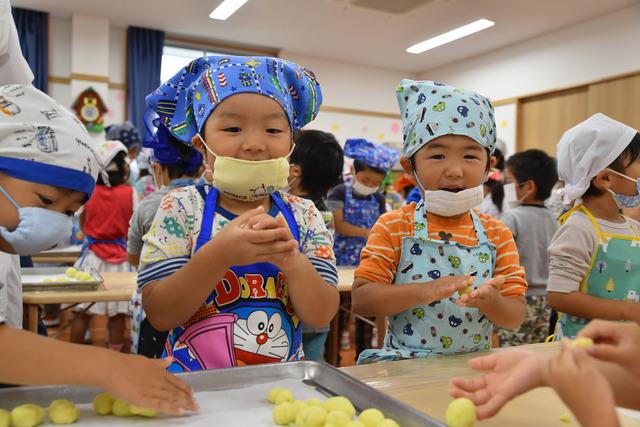 エプロン姿で団子を丸めている園児たちの写真