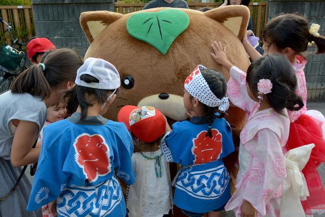 (写真)祭りのオープニングで登場したサプライズゲストの市営業部長「やはたいぬ」に大喜びの子どもたち