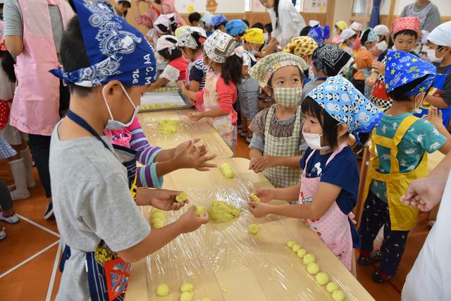 エプロン姿で団子を丸めている園児たちの写真