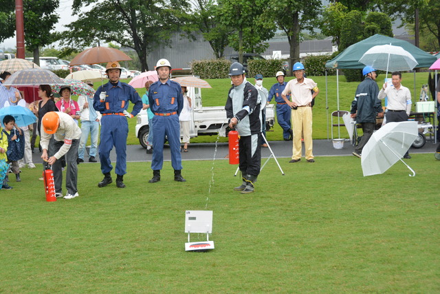 (写真)消火器を使用して訓練を行う男性