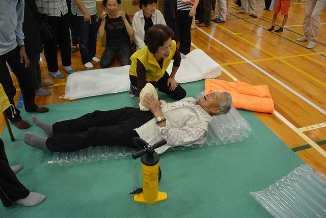 (写真)空気で膨らませた担架を体験する男性