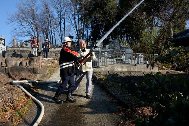 消防士と住民が消火栓からの放水訓練をしている写真