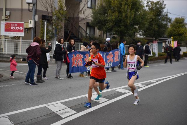 (写真)沿道の応援を背に走るランナー