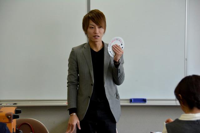 講師のプロマジシャン水野翔さんがトランプを持って説明している写真