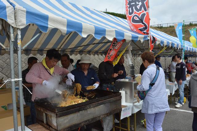 出店で男性が焼きそばを作っている写真