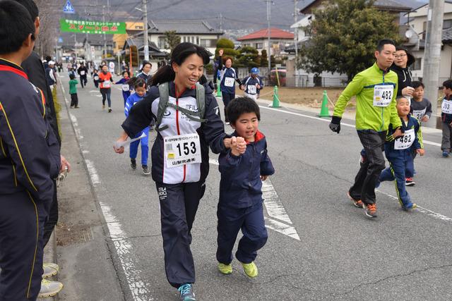 (写真)手をつなぎ、笑顔で走る親子