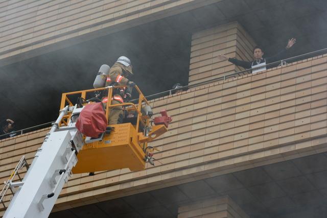 (写真)本館の屋上から助けを求める人とはしごで駆けつける隊員