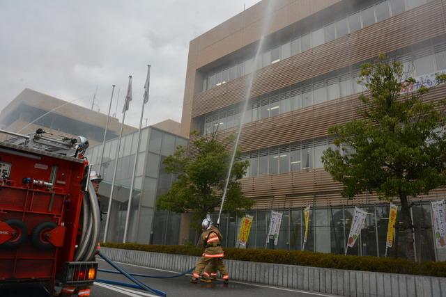 (写真)地上から屋上に向かって放水