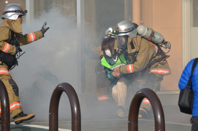 (写真)消防訓練にて店内にいた女性を消防職員が救出している様子
