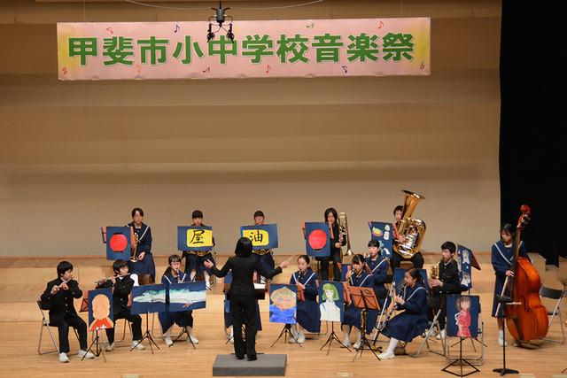 双葉ふれあい文化館にて竜王北中学校吹奏楽部がパネルを飾り演奏している写真