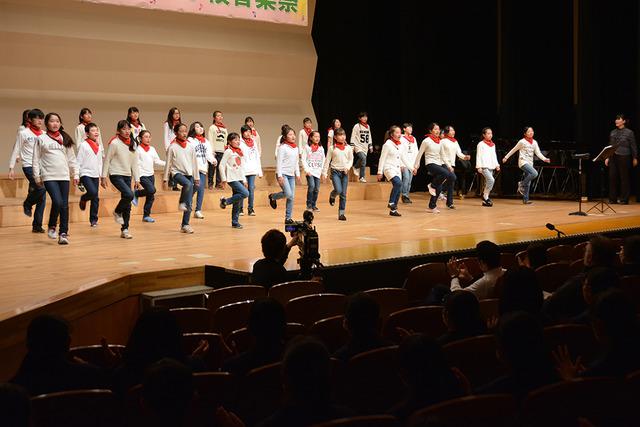 双葉ふれあい文化館にて敷島小学校合唱部の生徒たちが踊りながら歌っている写真