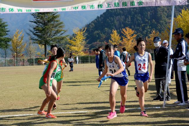 (写真)1区から2区へ襷を繋ぐ選手たち