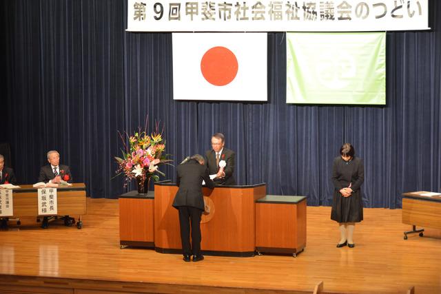敷島総合文化会館にて社会福祉協議会のつどいが行われ男性が表彰されている写真