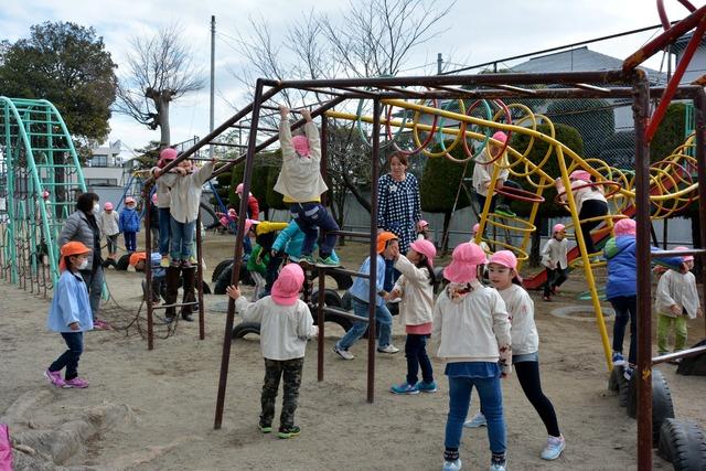 グラウンドの遊具で遊んでいる園児たちの写真