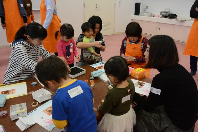 敷島保健福祉センターにて親子たちが一緒に色紙にシールを張るなど作業している写真