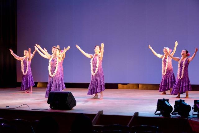 ステージでフラダンスを披露する女性たちの写真