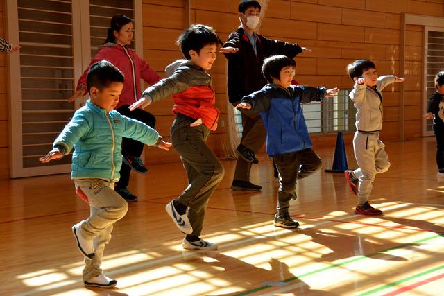 一列で片足立ちをしている子ども達の写真