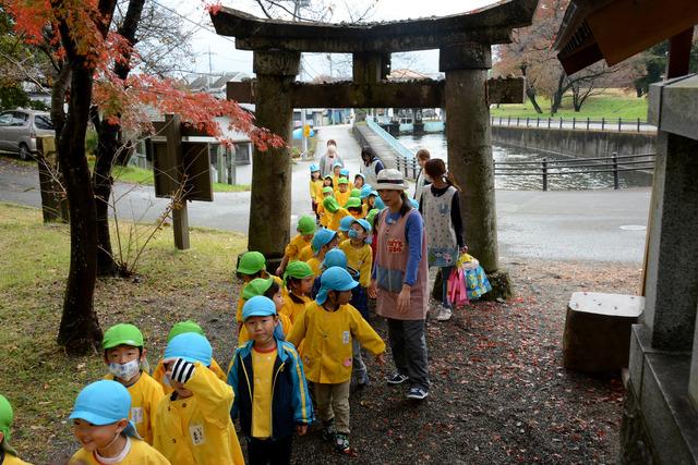 園児たちが二列に並んで鳥居をくぐる写真