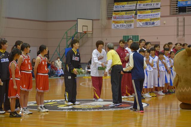 (写真)記念品を受け取る両チームの代表選手