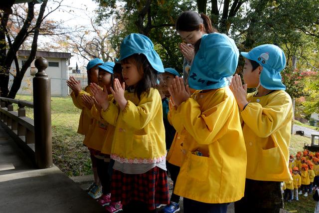 三社神社にて水色の帽子を被った園児たちがお参りをしている写真