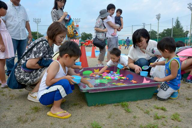 (写真)模擬店にて一生懸命に賞品を獲得しようとする子どもたち