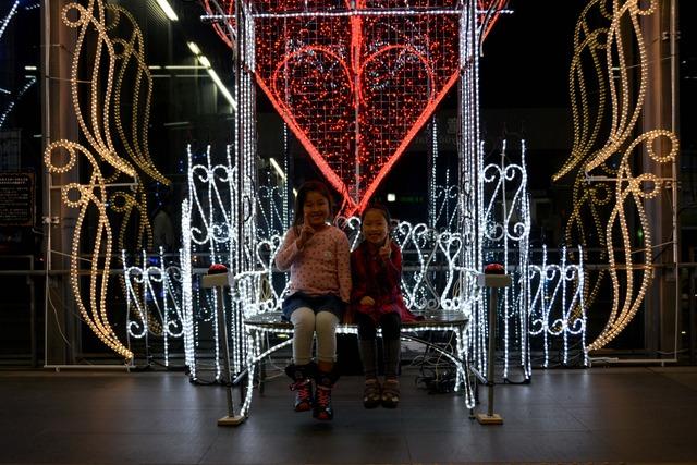 竜王駅南北自由通路にてハートのオブジェのイルミネーションで女の子二人が記念撮影をしている写真