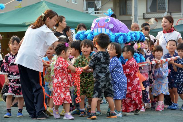 竜王西保育園の園庭にて甚平を着た園児たちが神輿をひいている写真