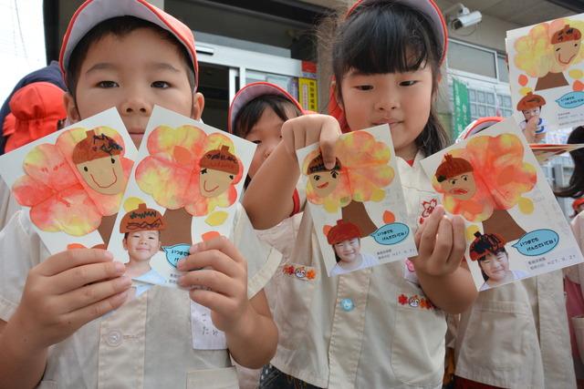 手作りしたはがきをもつ子ども達の写真