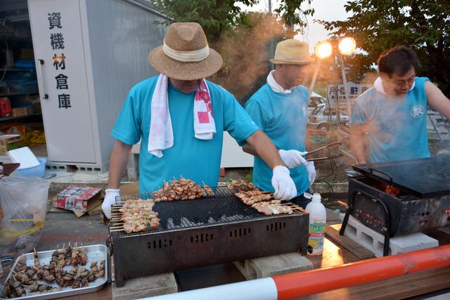 焼き鳥を焼く夜店の写真