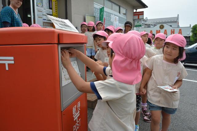 手作りしたはがきを並んで投函している子どもの写真