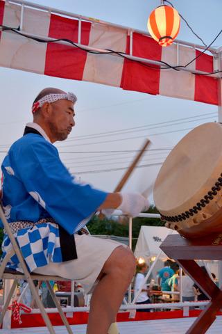 法被をきた男性が太鼓を演奏している写真