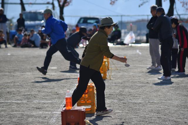 竜王新町大運動会のビン詰リレーで参加者が色水をお玉を使って運んでいる写真