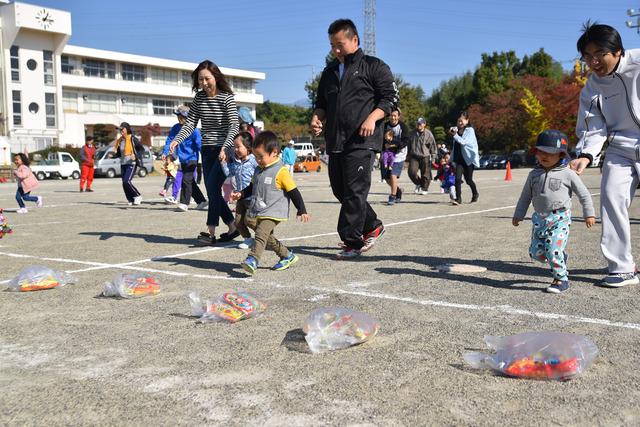 竜王新町大運動会の宝ひろいの種目で親子が袋に入ったお菓子に向かって走っている写真