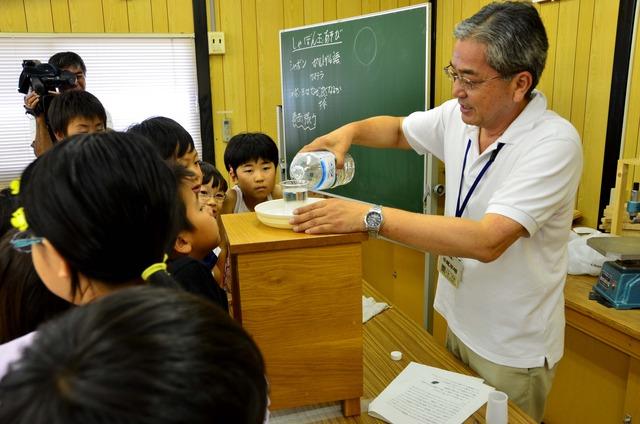 子どもたちの前に立ち実験をする小尾平館長の写真