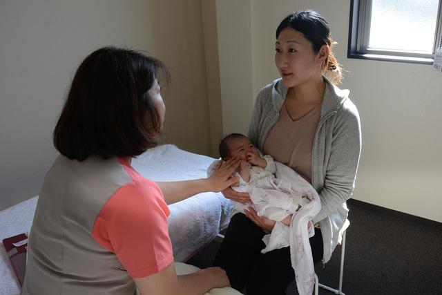 (写真)助産師に育児相談をするお母さん