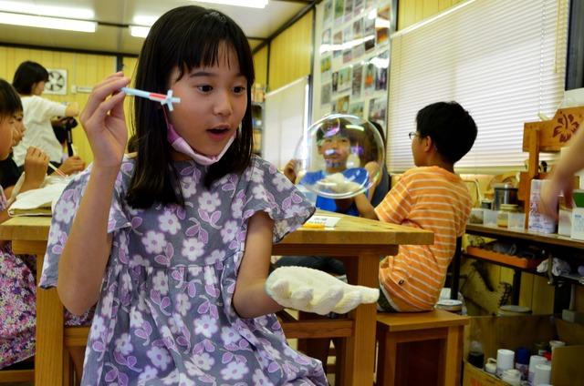 シャボン玉のお手玉をする子どもの写真