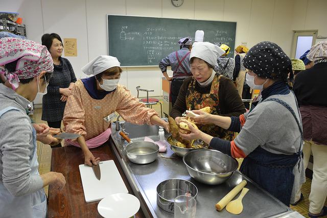 (写真)芋の皮むきをする参加者たち