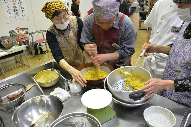 (写真)芋をペースト状にすりつぶす参加者