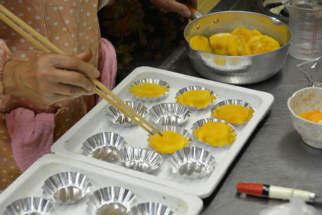 (写真)スイートポテトの土台を型にいれる様子