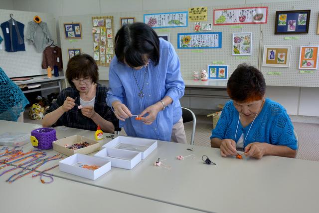 (写真)毛糸のアクセサリーを作る参加者