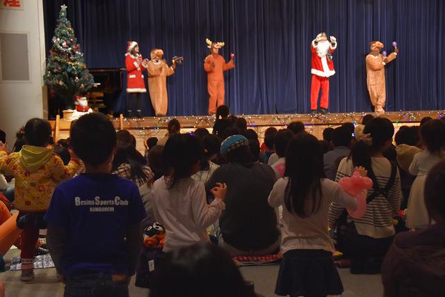 (写真)サンタクロースやトナカイたちが一緒に歌って踊っている様子